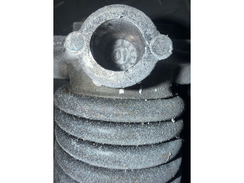 Broken torsion spring on a residential garage door with visible gap at center where the spring snapped