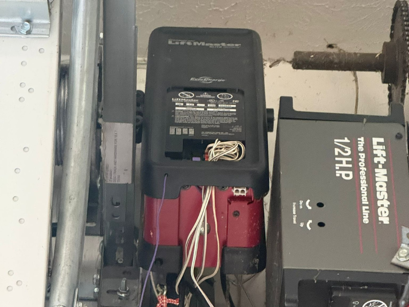 Close-up of a technician's hands using a screwdriver to diagnose a mechanical unit, the kind of hands-on inspection an opener repair calls for